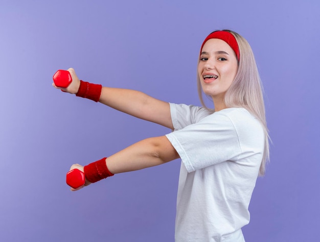 Alegre joven caucásica deportiva con tirantes vistiendo diadema