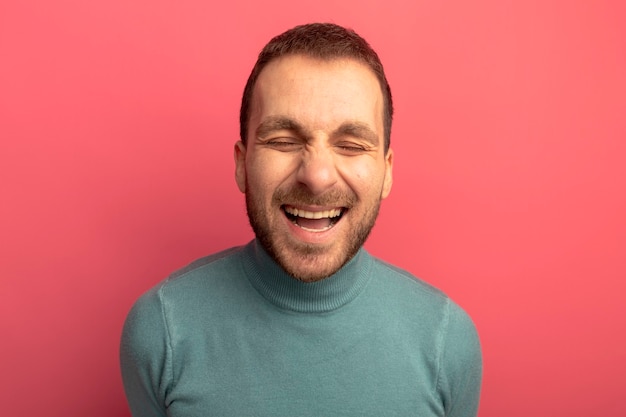 Alegre joven caucásico riendo con los ojos cerrados aislado sobre fondo carmesí