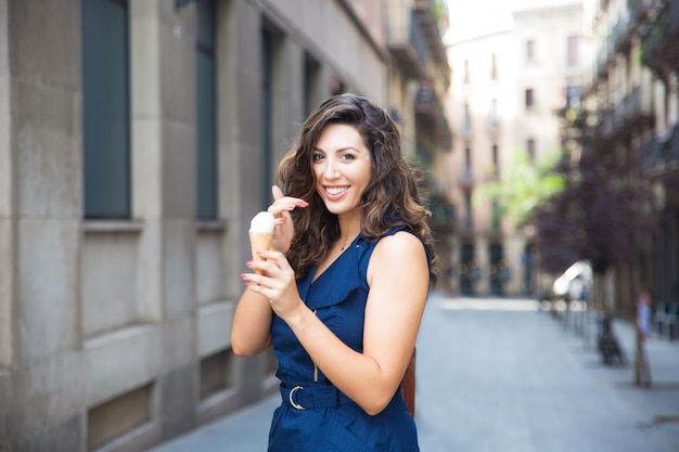 Alegre joven comiendo helado al aire libre