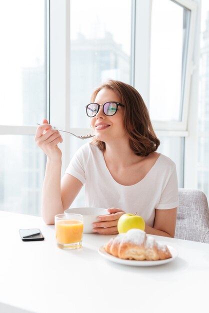 Alegre joven comiendo hojuelas de maíz