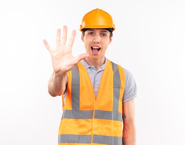 Alegre joven constructor en uniforme mostrando cinco