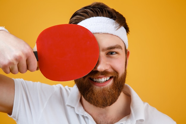 Alegre joven deportista con raqueta para tenis de mesa.