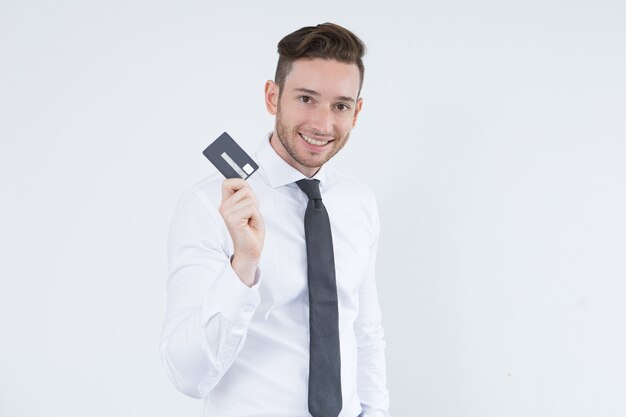 Alegre joven ejecutivo con tarjeta de crédito