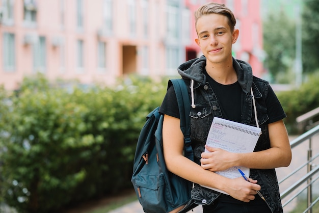 Foto gratuita alegre joven con estudios