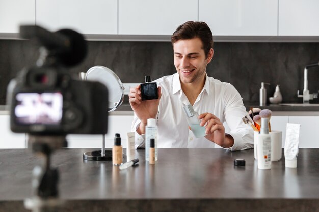 Alegre joven filmando su episodio de video blog