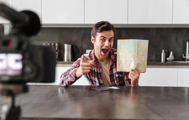 Alegre joven filmando su episodio de video blog