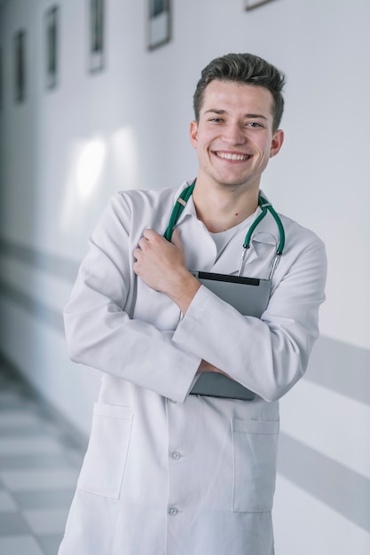 Foto gratuita alegre joven médico con tableta digital