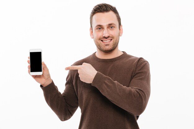 Alegre joven mostrando la pantalla del teléfono móvil