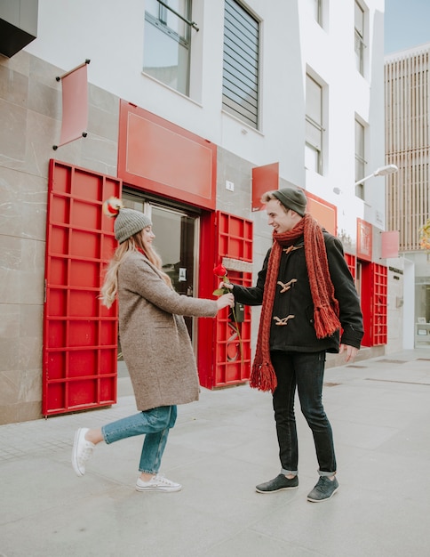 Alegre joven regalos rosa a novia