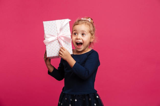 Alegre joven rubia con caja de regalo y se regocija