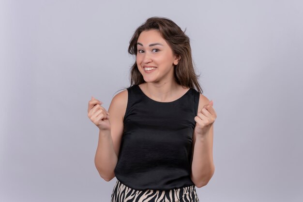 Alegre joven vistiendo camiseta negra sobre pared blanca