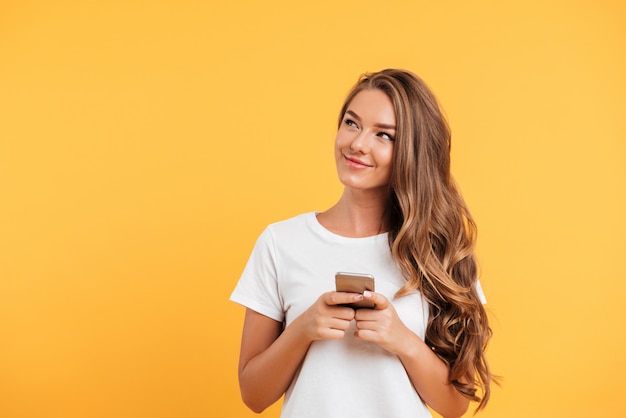 Alegre linda hermosa joven chateando por teléfono móvil