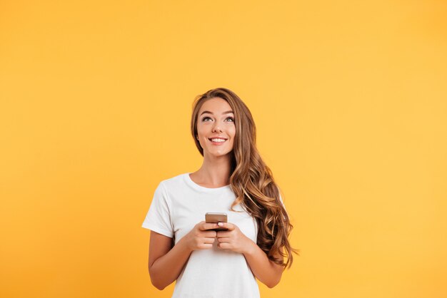 Alegre linda hermosa joven chateando por teléfono móvil