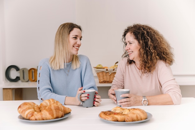 Alegre madre e hija desayunando