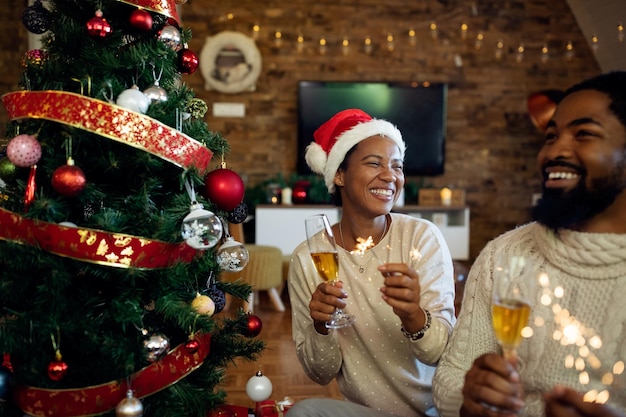 Alegre mujer afroamericana divirtiéndose con su esposo en Navidad