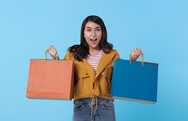 Alegre mujer asiática adolescente feliz disfrutando de las compras que lleva bolsas de compras