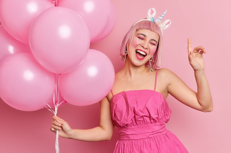 Foto gratuito alegre mujer asiática inclina la cabeza y levanta el brazo se siente muy feliz en la fiesta