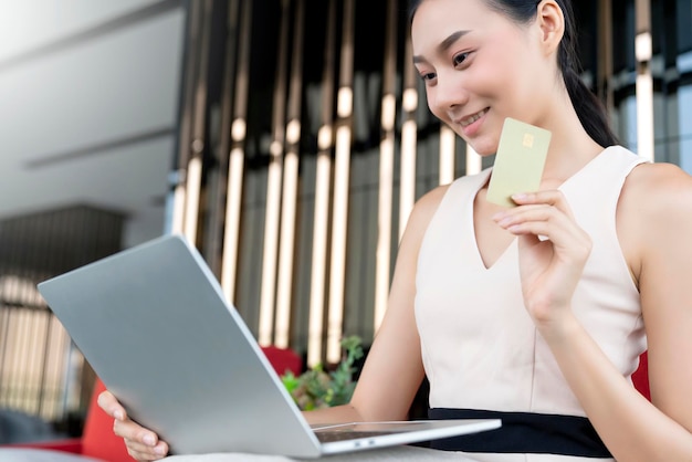 Alegre mujer atractiva mujer felicidad mano alegre asimiento portátil teléfono inteligente tarjeta de crédito compras en línea desde casa cuarentena blanca distanciamiento social en covid19 brote de propagación del virus corona