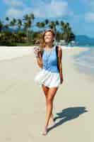 Foto gratuita alegre mujer caminando por la playa en verano