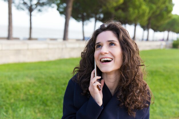 Alegre mujer despreocupada disfrutando agradable charla telefónica