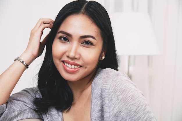 Foto gratuita alegre mujer filipina tocando el pelo