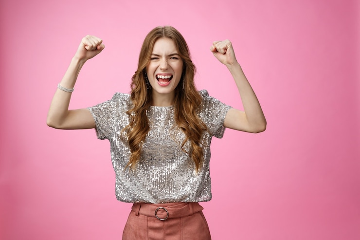 Foto gratuito alegre mujer de glamour guapa de apoyo actuando atrevida atrevida levantar los puños apretados gritando hacer ...