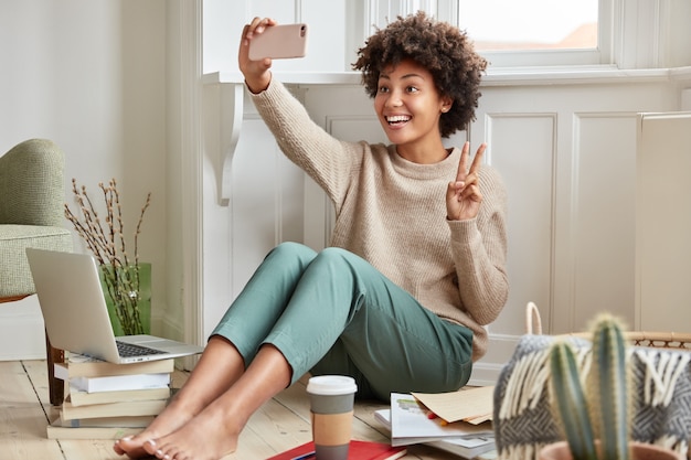 Alegre mujer negra hace el signo de la paz