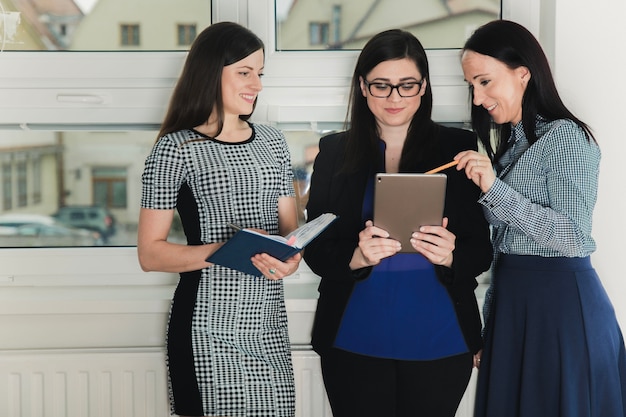 Alegre mujeres con tableta en la oficina