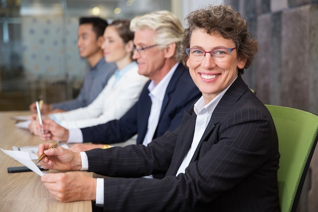 Alegre negocios de alto nivel que se sienta en la reunión