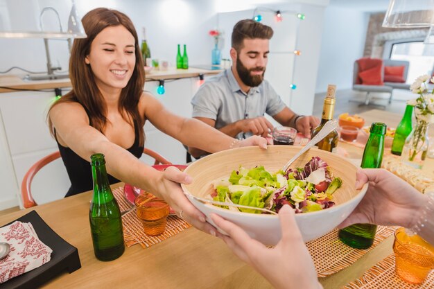 Alegre niña con los amigos en la mesa