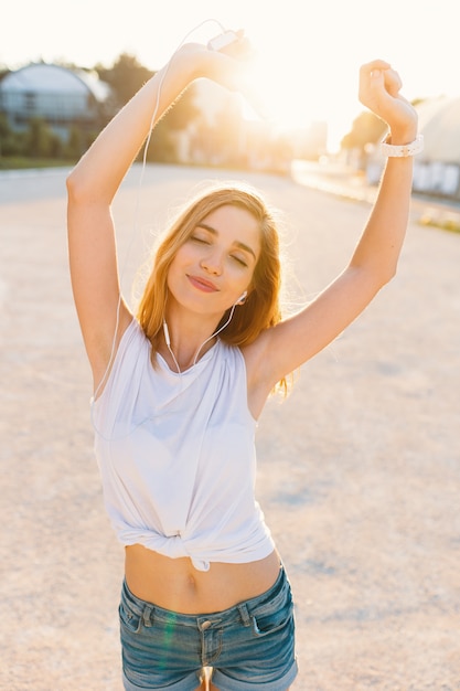 Foto gratuita alegre niña bailando en la calle en un día soleado cogidos de la mano u