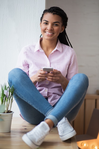 Alegre niña negra con un dispositivo moderno