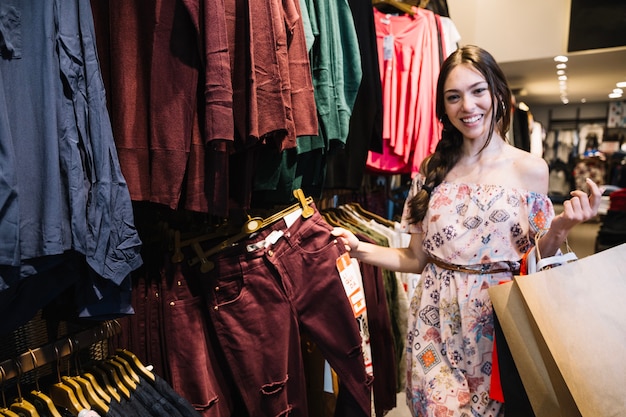 Alegre niña posando en la tienda de ropa