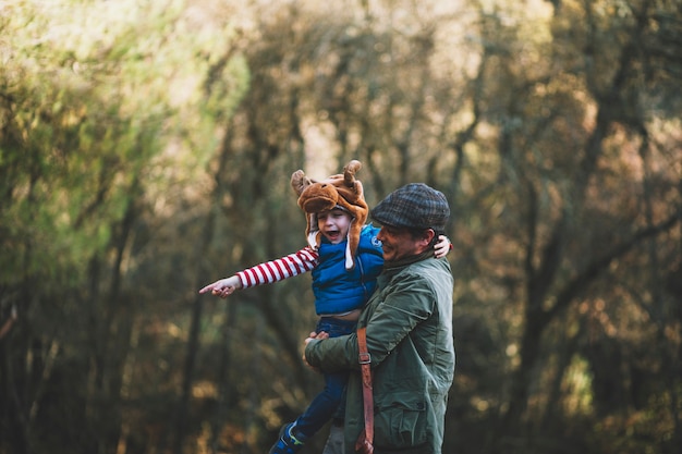 Foto gratuita alegre padre e hijo en el bosque