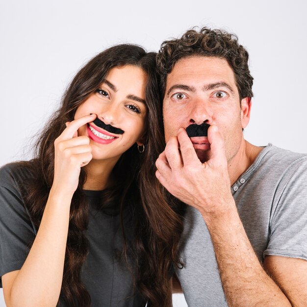 Alegre papá e hija con bigotes falsos