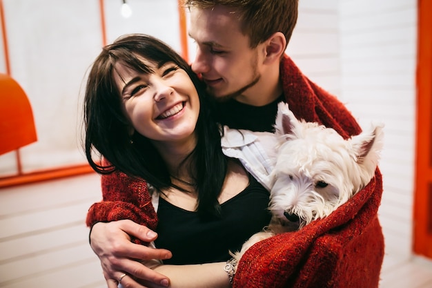 Foto gratuita alegre pareja cuddling con el perro en cuadros