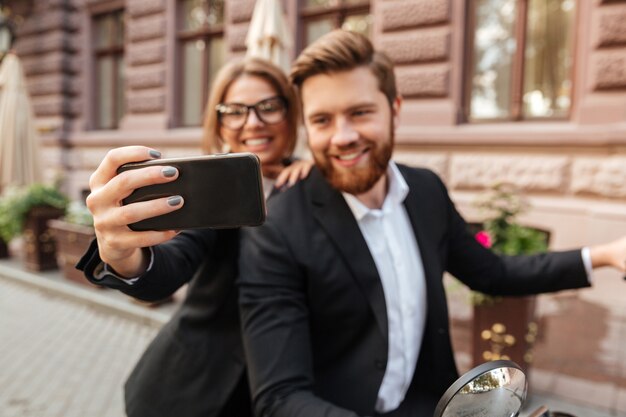 Alegre pareja elegante sentado en moto moderna al aire libre