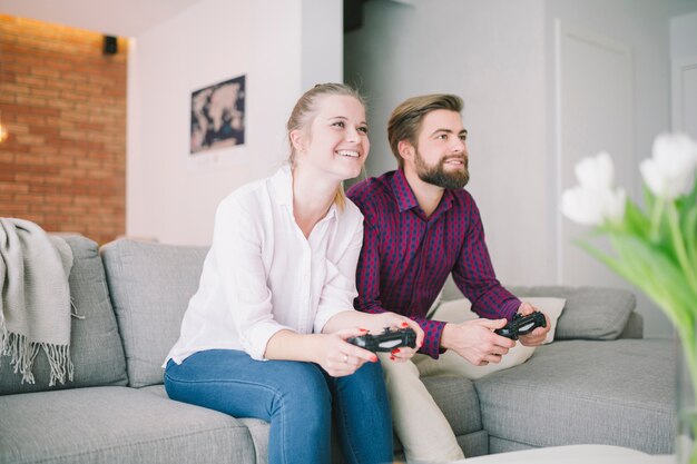 Alegre pareja emocionada sentado con gamepads