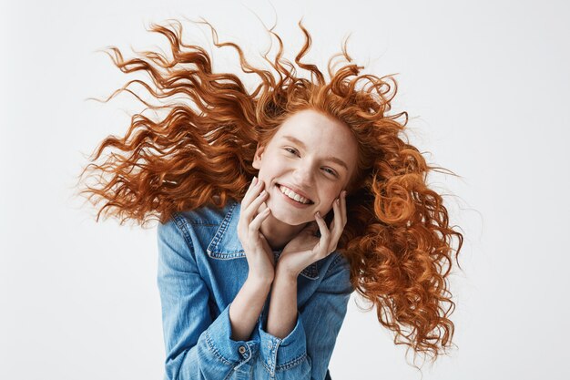 alegre pelirroja mujer con cabello rizado volando sonriendo riendo.