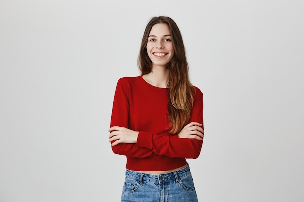 Alegre sonriente mujer sonriente cámara, cofre de brazos cruzados