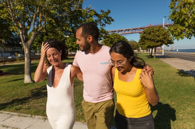 Alegres amigos abrazándose en el parque