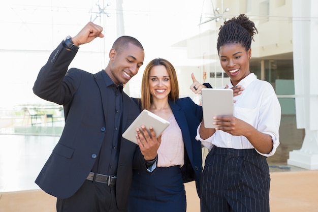 Alegres colegas de negocios con tabletas