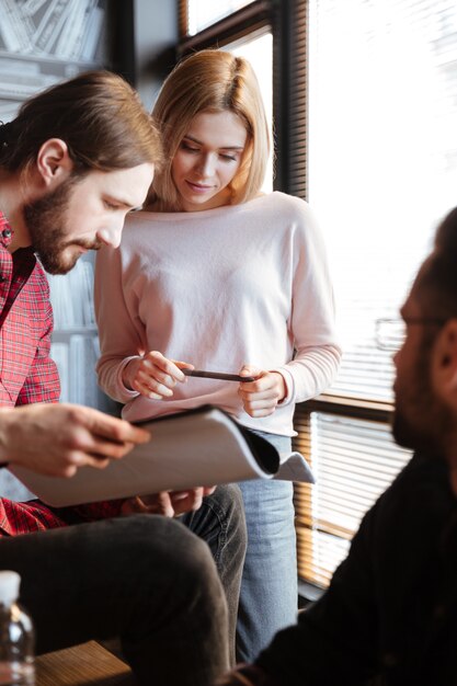 Alegres colegas sentados en la oficina y coworking