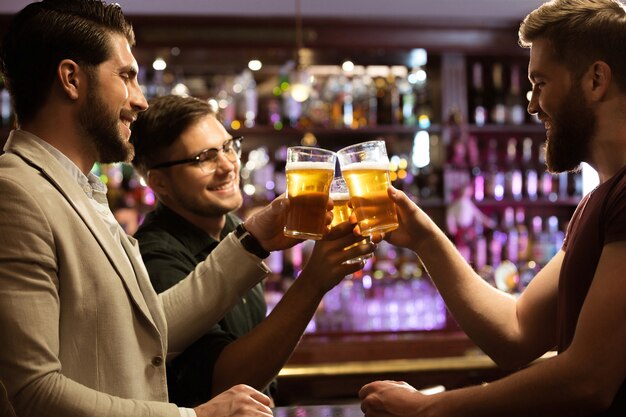 Alegres jóvenes brindando con cerveza