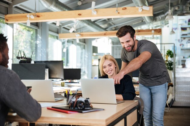 Alegres jóvenes colegas sentados en la oficina de coworking