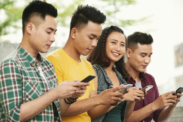 Alegres jóvenes con teléfonos inteligentes