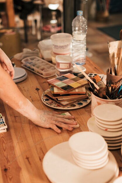 Alfareros femeninos arreglando la paleta de cerámica en mesa de madera