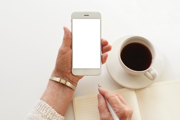 Alguien está usando el teléfono mientras toma una taza de café