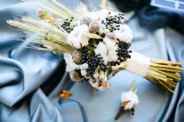 Algunas decoraciones de la boda, flores sobre fondo de tela azul, vista de ángulo alto.