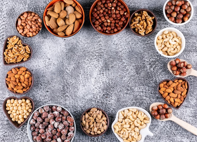 Algunas nueces surtidas en un mini tazón diferente en una mesa de piedra negra